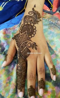 a woman's hand with henna tattoos on it