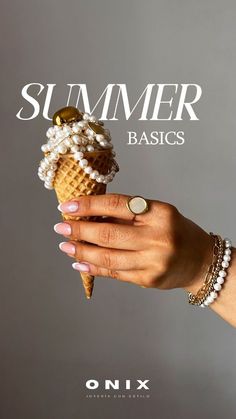 a woman's hand holding an ice cream cone with pearls on it and the words summer basics