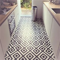 a kitchen with a black and white pattern on the floor