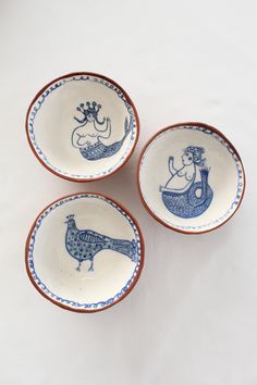 three blue and white bowls with designs on them