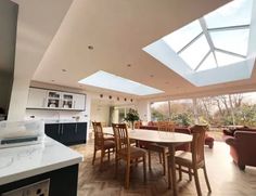 a large open kitchen and dining room with skylights