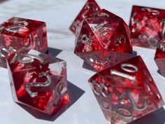 red dices with silver numbers on them sitting on a white tableclothed surface