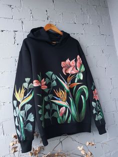 Boho Flower Hoodie for Women, a perfect blend of comfort and style. This sweatshirt features custom painting with delicate floral designs, embracing the essence of boho and cottagecore aesthetics. Each design is meticulously hand-painted, ensuring a unique and artisanal touch to every hoodie. Additionally, the artwork can be customized upon request, allowing you to personalize the floral motif to your liking. The cute coquette pullover hoodie is designed to be both fashionable and cozy, making it an ideal addition to your wardrobe. Whether you're lounging at home or stepping out for a casual day, this hoodie effortlessly combines charm and warmth. Embrace your bohemian spirit with this unique and stylish piece! The drawing is applied by hand with brushes and special paints. Therefore, each Art On Hoodies, Artistic Long Sleeve Hoodie For Fall, Sweatshirt Painting, Artistic Cotton Hooded Hoodie, Artistic Cotton Hoodie, Artistic Hooded Hoodie For Fall, Painted Sweatshirt, Painted Hoodies, Painted Hoodie