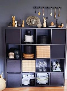 a shelf filled with lots of plates and bowls next to a wall mounted rack full of dishes