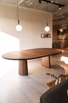 an image of a table in the middle of a room with lights hanging from it