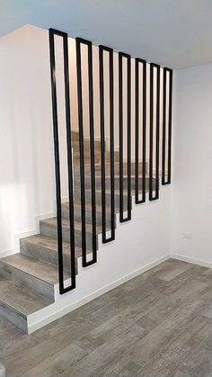 an empty room with stairs and railings on the wall next to wooden flooring