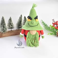 a crocheted christmas gnome with green hair and red shirt next to pine trees