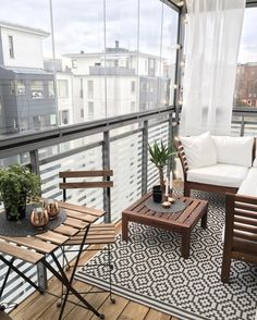 a balcony with wooden furniture and white curtains