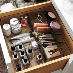 the drawer is full of makeup and other beauty products, including brushes, eyeliners