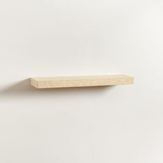 a wooden shelf on a white wall with no one in the room or furniture around it