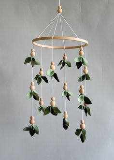 a mobile with leaves and wooden beads hanging from it