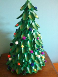 a paper plate christmas tree sitting on top of a wooden table