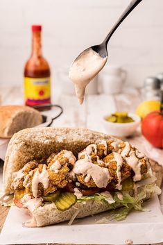 a spoon is lifting some kind of food out of a pita bread with sauce on it