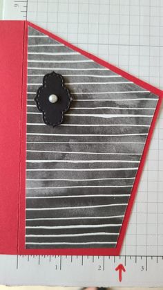 a close up of a piece of paper with a black flower on it and a ruler next to it