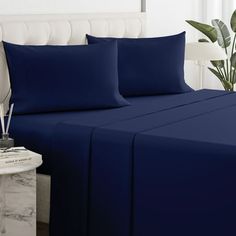 a bed with blue sheets and pillows on it