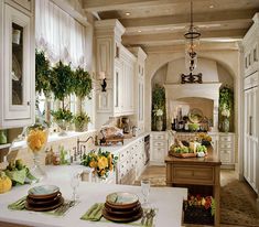 a kitchen filled with lots of white cabinets and counter top space next to a dining room table