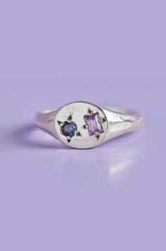 Experience the perfect blend of elegance and playfulness with our Delicate Pickles Mini Signet. Its eye-catching gemstones, including a mesmerizing blue-green Sapphire and an Amethyst, star-set in the face, make it a must-have for those who love to have fun with their jewellery. Use the drop down to select your ring size.If you are unsure of your ring size refer to our size guide. Please select your ring size carefully, and reach out if you have any questions. Details925 Sterling SilverHandcraft Signet Ring With Gemstones, Silver Clay Jewelry Ideas, Clay Ring, Ring Inspo, Silver Clay, Blue Green Sapphires, Fashion Themes, Silver Signet Ring, Classy Jewelry