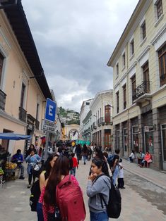 many people are walking down the street in front of buildings with signs that read e