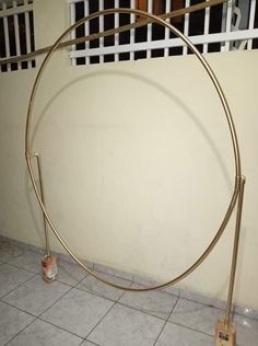 a large round metal object on the ground near a wall with bars attached to it