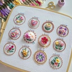 a table topped with lots of different types of embroidery