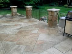 an outdoor grill and patio area with stone pavers