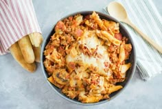 a bowl filled with pasta and meat on top of a table