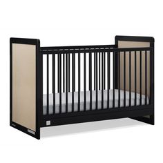 a black crib with a white sheet on the bottom and beige sheets on the bottom