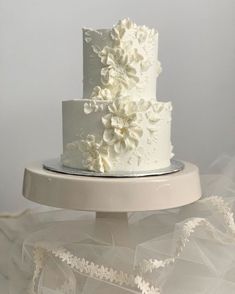 a white wedding cake with flowers on top