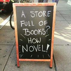 a sign on the sidewalk that says, a store full of books? how novel?