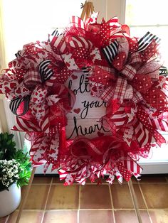 a red and white wreath with words on it