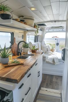 the interior of a camper with wood counter tops and plants on the windowsill