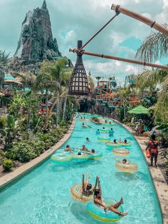 people are floating on rafts in the water at an amusement park