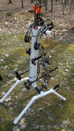 an archery set up in the woods with arrows and bows on it's back