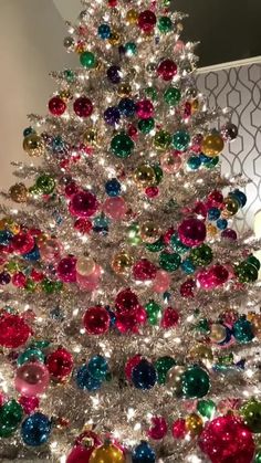 a brightly colored christmas tree with lots of ornaments on it's top and bottom