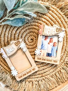 two personalized wooden frames sitting on top of a wicker basket next to a plant