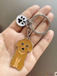 a person holding a keychain with a dog on it