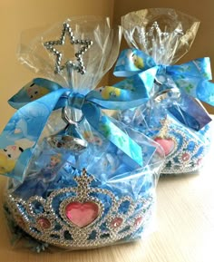 two blue shoes with bows on them sitting on top of a wooden table in front of a mirror