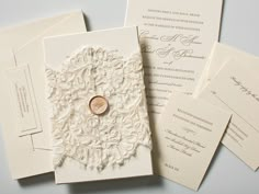 the wedding stationery is laid out on top of each other, including a ring