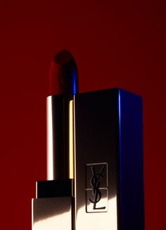 a close up of a lipstick on a red surface with a blue box in the foreground