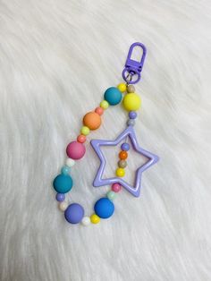 a pacifier with beads and a star hanging from it's side on a white fur surface