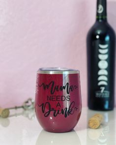 a wine glass sitting on top of a table next to a bottle and corks