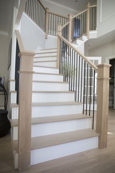 a white staircase with wooden handrails in a house