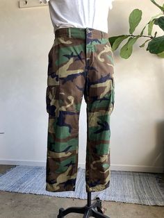 Vintage 1980s Military Camo Cargo Button Fly Pants by Propper. Camo patterned military pants with a button fly closure and adjustable straps at waist. Cotton blend fiber content. Condition overall is great with no major flaws noted. No rips, tears, or staining. Please see all photos for details. Refer to measurements below to ensure a proper fit 17" across waist (size 34) 21" across hip 29" inseam Button Fly Pants, Military Pants, Camo Pants, Military Fashion, Mens Pants, Camo, Overalls, Cotton Blend, Trousers