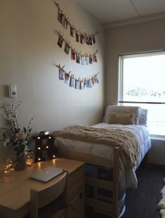 a bed room with a neatly made bed next to a window and a laptop on a desk