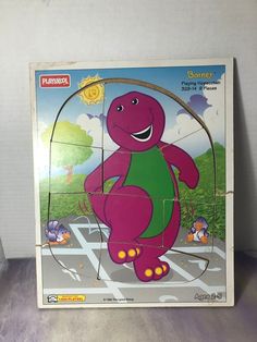 the children's wooden puzzle has an image of a purple dinosaur on it