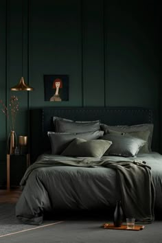 a bedroom with dark green walls and bedding