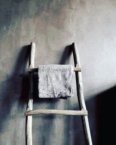 an old wooden ladder leaning against a wall with a towel hanging on it's side