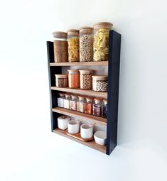 a shelf filled with lots of different types of spices and condiments next to a white wall