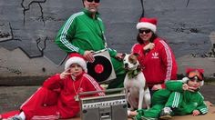 a group of people in matching outfits posing for a photo with a dog and record player