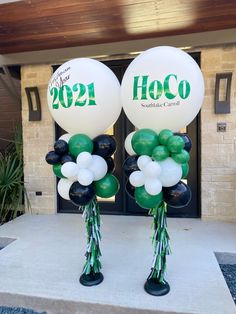 two balloons with the words hoco on them are standing in front of a building